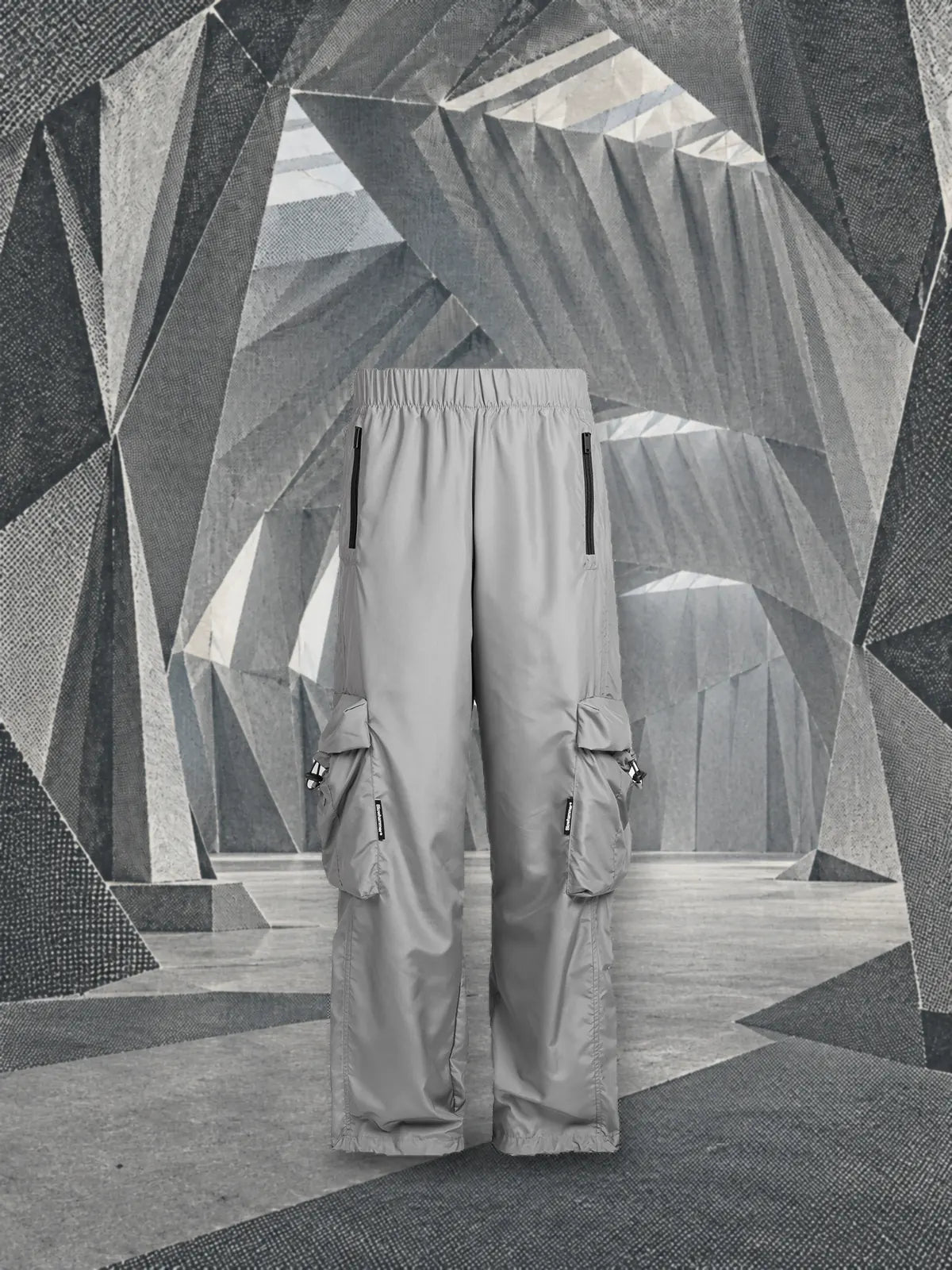 Le pantalon cargo gris Coloured debout dans un hangar de papier argenté plié, imprimé en trame.