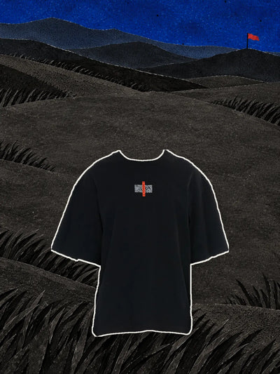 Czarny T-shirt Flag z czerwoną metką na piersi, nad wzgórzami z czarnego papieru pod niebieskim nocnym niebem.