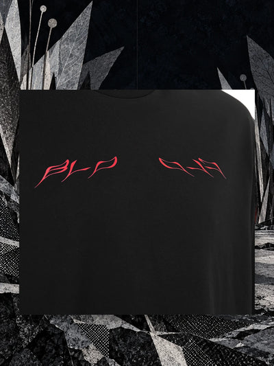 Fragment przodu czarnego T-shirtu Insectide, z czerwonym napisem, zawieszony na nitce wśród papierowych ostrzy w nocy.