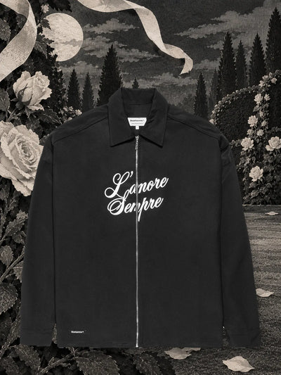 La sobrecamisa con cremallera negra L'amore sempre en un jardín nocturno de papel negro, entre rosas y cintas de papel blanco.