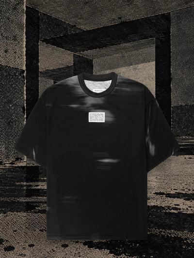 Czarny T-shirt Leak w pokoju z ciemnego papieru, z czarnym tuszem spływającym na podłogę długimi smugami.