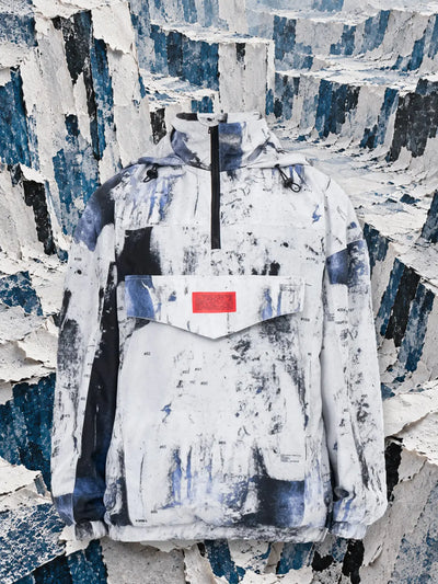 Bílý anorak Rugged mezi stěnami z roztrhaného bílého a modrého papíru.