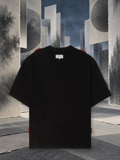 Czarny T-shirt Stream wśród zawieszonych paneli z szarego papieru, w półmroku.