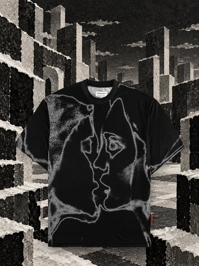 Czarny T-shirt Unkiss Black wśród sześcianów z podartego białego i czarnego papieru, pod szarym niebem.
