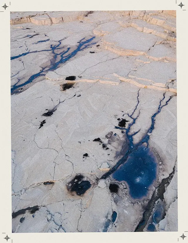 Una cava di calce vista dall'alto, con vene di un blu più scuro della stampa.
